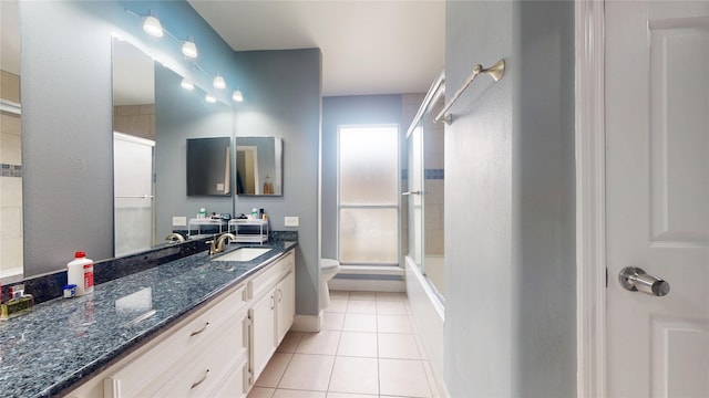 bathroom with vanity, tile patterned floors, toilet, and a shower with door