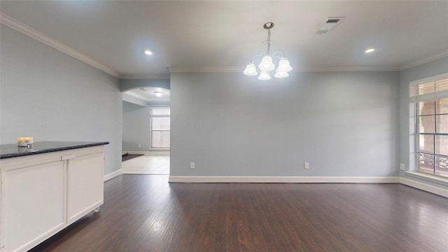 unfurnished dining area featuring dark wood-style floors, arched walkways, baseboards, and ornamental molding