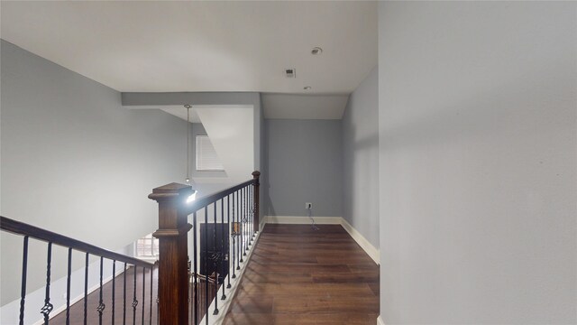 hall featuring baseboards, an upstairs landing, visible vents, and wood finished floors