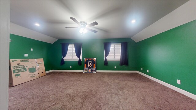 interior space featuring carpet floors, ceiling fan, baseboards, and vaulted ceiling