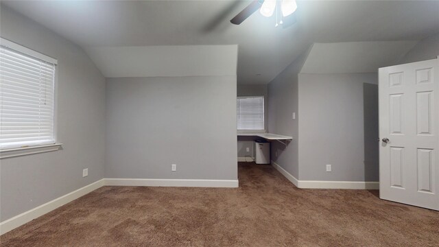 interior space with baseboards, carpet floors, lofted ceiling, and a ceiling fan