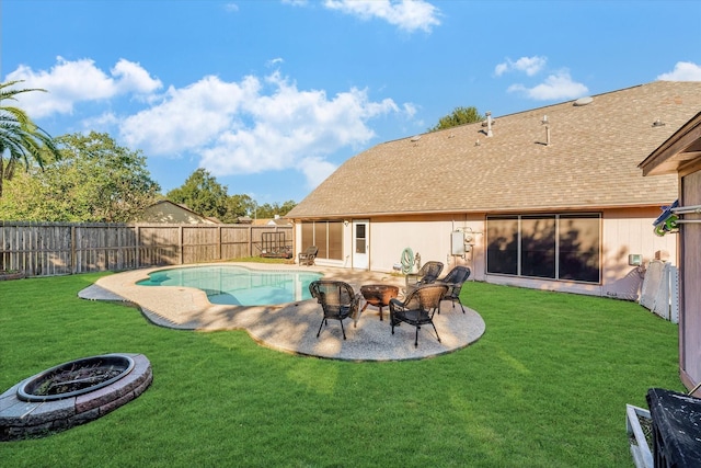 view of swimming pool with a patio area, a yard, an outdoor fire pit, and a fenced backyard