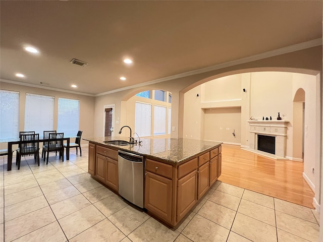 kitchen featuring visible vents, crown molding, stainless steel dishwasher, light tile patterned flooring, and a sink