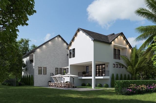 back of property with a patio area, a lawn, brick siding, and a balcony