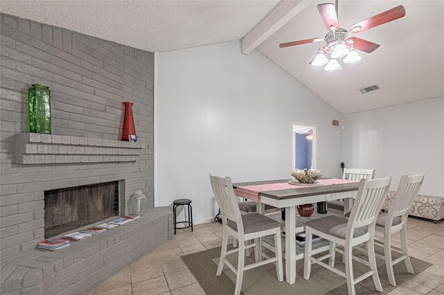 dining room featuring tile patterned floors, visible vents, lofted ceiling with beams, a textured ceiling, and a fireplace