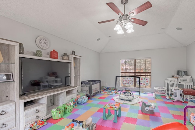 recreation room featuring a textured ceiling, vaulted ceiling, and ceiling fan