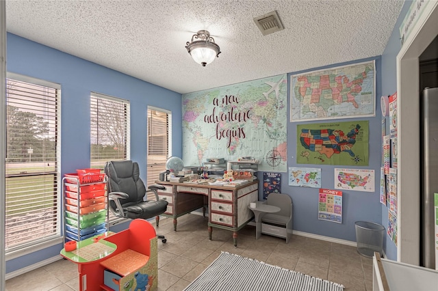 tiled home office featuring visible vents, a textured ceiling, and baseboards