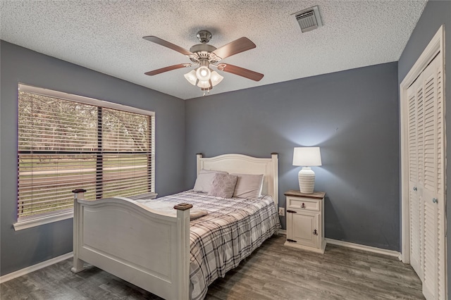 bedroom featuring wood finished floors, visible vents, and baseboards