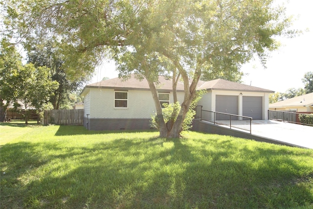 rear view of property featuring brick siding, fence, a lawn, a garage, and crawl space