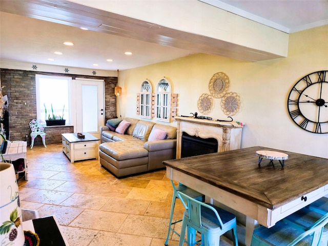 living area with recessed lighting, stone tile floors, brick wall, and a fireplace