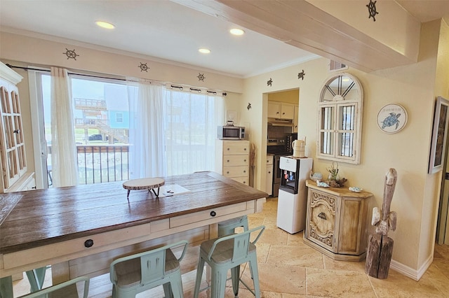 kitchen featuring visible vents, ornamental molding, under cabinet range hood, appliances with stainless steel finishes, and baseboards