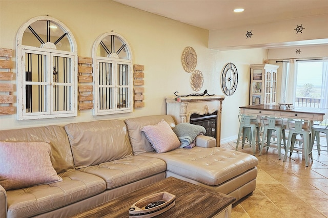 living area with light tile patterned flooring, a glass covered fireplace, and recessed lighting