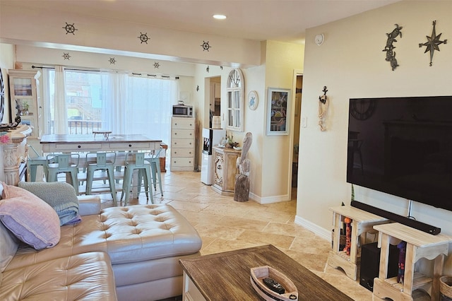 living area with stone tile flooring, recessed lighting, and baseboards