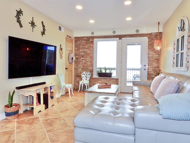 living room with visible vents, recessed lighting, and brick wall