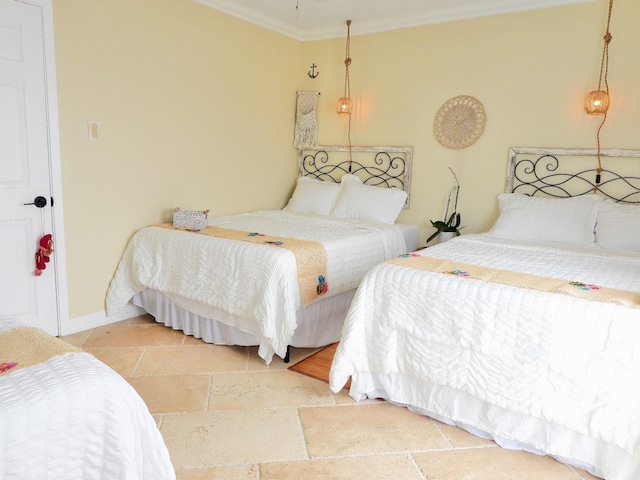 bedroom featuring crown molding, baseboards, and stone tile flooring