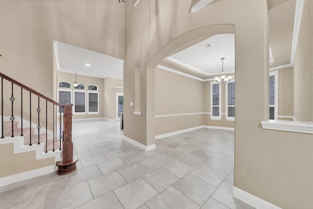 entrance foyer with crown molding, stairway, baseboards, and visible vents