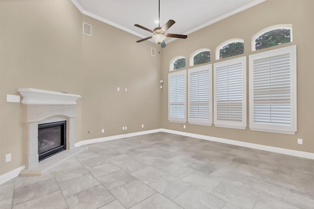 unfurnished living room with visible vents, baseboards, a glass covered fireplace, and crown molding