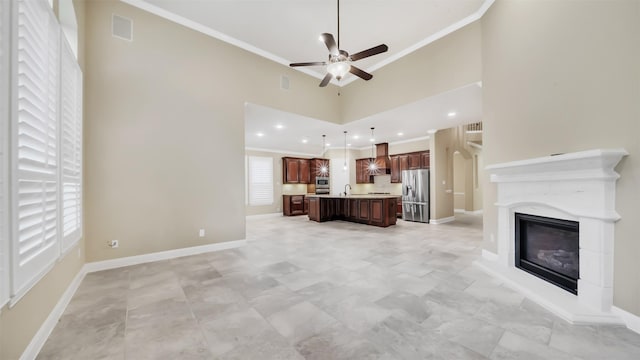 unfurnished living room featuring a glass covered fireplace, crown molding, visible vents, and baseboards