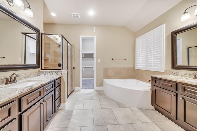 bathroom with visible vents, two vanities, a stall shower, a sink, and a bath