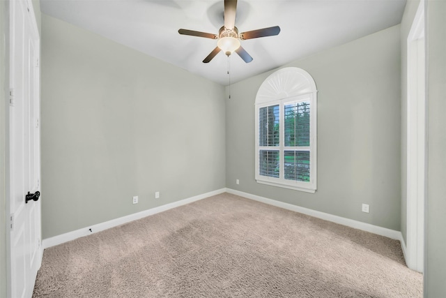 carpeted empty room featuring baseboards and ceiling fan