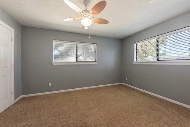 carpeted empty room featuring ceiling fan, baseboards, and a textured ceiling