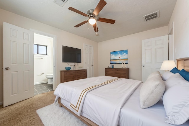 carpeted bedroom featuring ceiling fan, visible vents, and connected bathroom