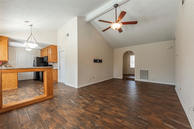 unfurnished living room with visible vents, beamed ceiling, a ceiling fan, dark wood-style floors, and arched walkways