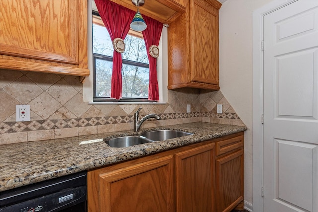 kitchen with brown cabinets, black dishwasher, and a sink