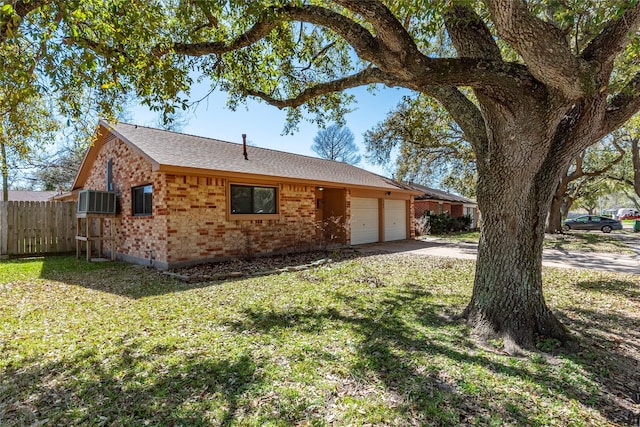 exterior space featuring fence, cooling unit, concrete driveway, an attached garage, and brick siding