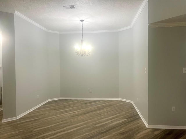 spare room with a textured ceiling, an inviting chandelier, dark wood-style floors, and ornamental molding