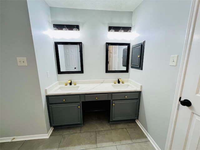 full bath with a sink, baseboards, double vanity, and tile patterned floors