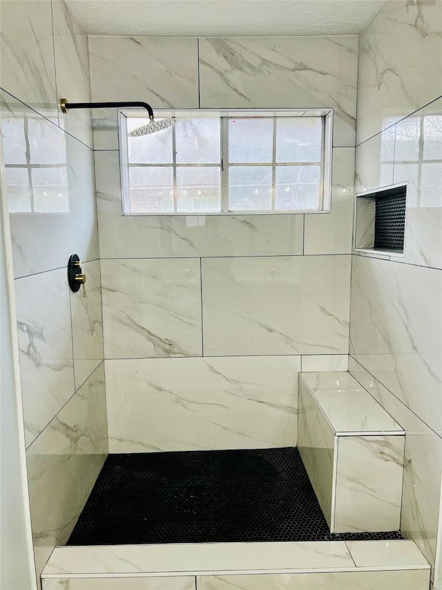 bathroom featuring a healthy amount of sunlight and tiled shower