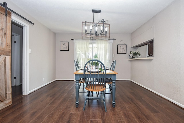 dining room featuring a barn door, baseboards, and wood finished floors