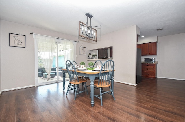 dining space featuring dark wood-style floors, visible vents, a notable chandelier, and baseboards