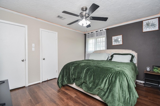 bedroom with visible vents, ceiling fan, ornamental molding, wood finished floors, and a textured ceiling