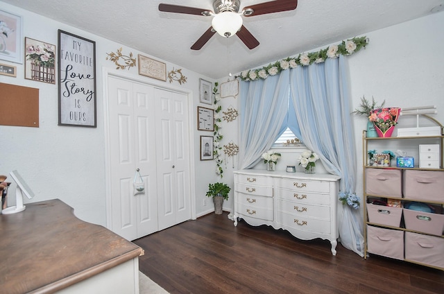 interior space with dark wood finished floors, a textured ceiling, and a ceiling fan