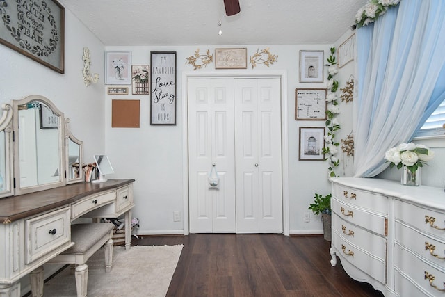 foyer with dark wood finished floors, ceiling fan, baseboards, and a textured ceiling