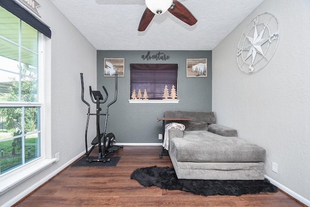 sitting room featuring wood finished floors, baseboards, and a textured wall