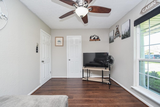 sitting room featuring wood finished floors, baseboards, a textured wall, and a textured ceiling