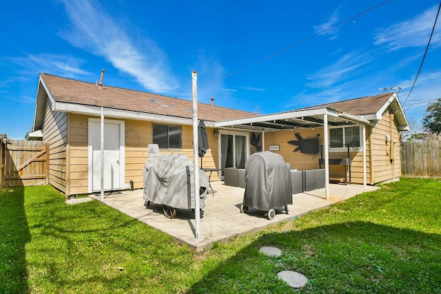 rear view of house with a patio area, a lawn, and fence