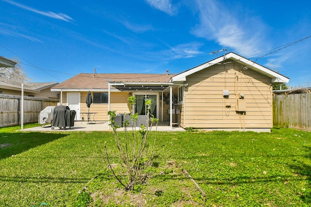 rear view of property featuring a lawn, a patio, and a fenced backyard