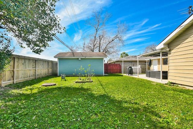 view of yard with an outbuilding, a patio, and a fenced backyard