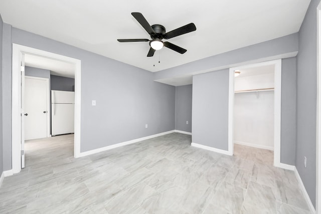 unfurnished bedroom with a closet, ceiling fan, freestanding refrigerator, and baseboards