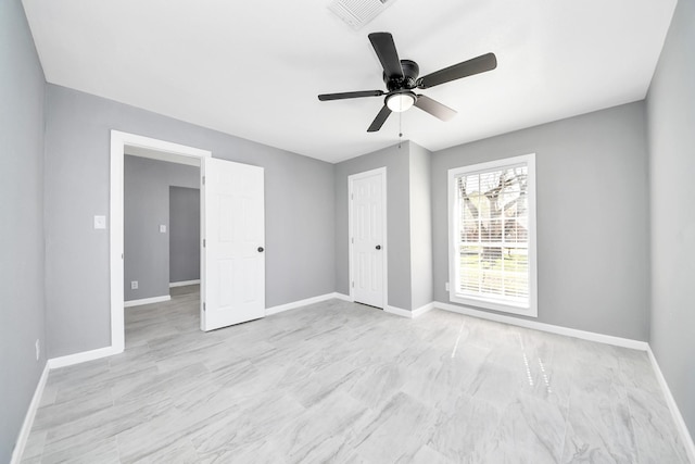 empty room with visible vents, ceiling fan, and baseboards