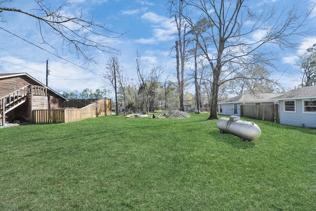 view of yard featuring stairs and fence