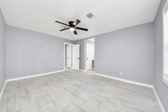 spare room with visible vents, ceiling fan, and baseboards