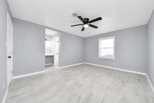 unfurnished room with visible vents, a ceiling fan, and baseboards