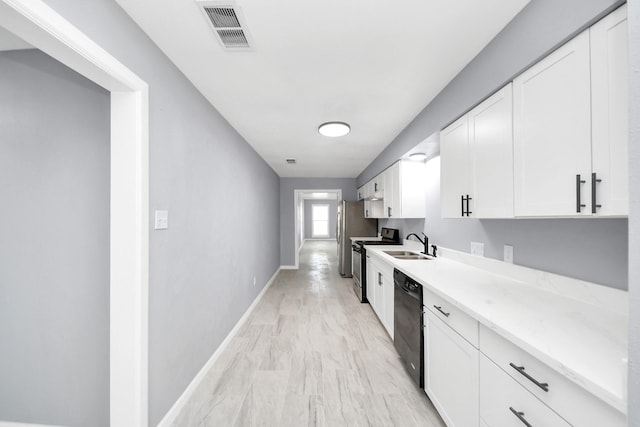 kitchen featuring visible vents, appliances with stainless steel finishes, white cabinetry, and a sink