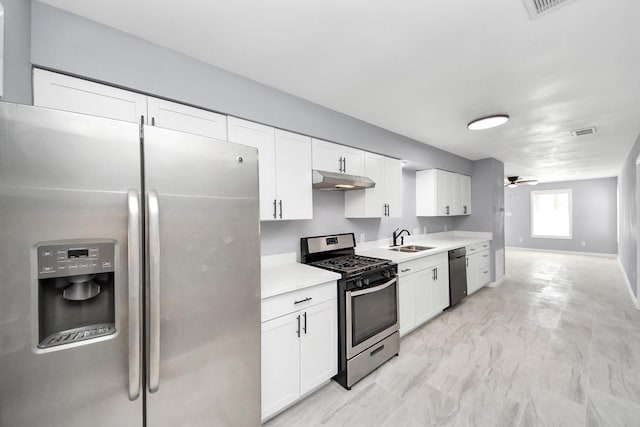 kitchen featuring a sink, under cabinet range hood, appliances with stainless steel finishes, white cabinets, and light countertops