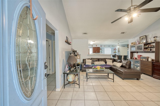 living room featuring light tile patterned floors, visible vents, bar area, and lofted ceiling